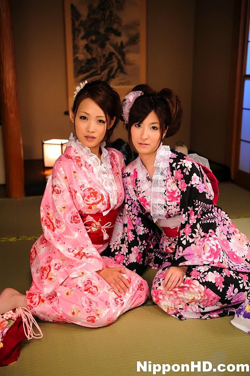 A pair of Japanese Geishas model together in their brightly colored kimonos