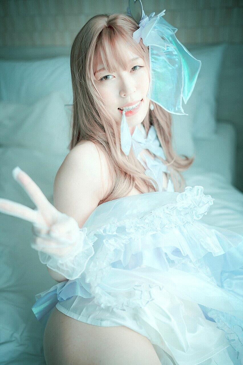 Saucy South Korean girl posing seductively in her white dress and stockings